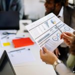 What People Risks Usually Cost Businesses the Most Money? A woman holding a document