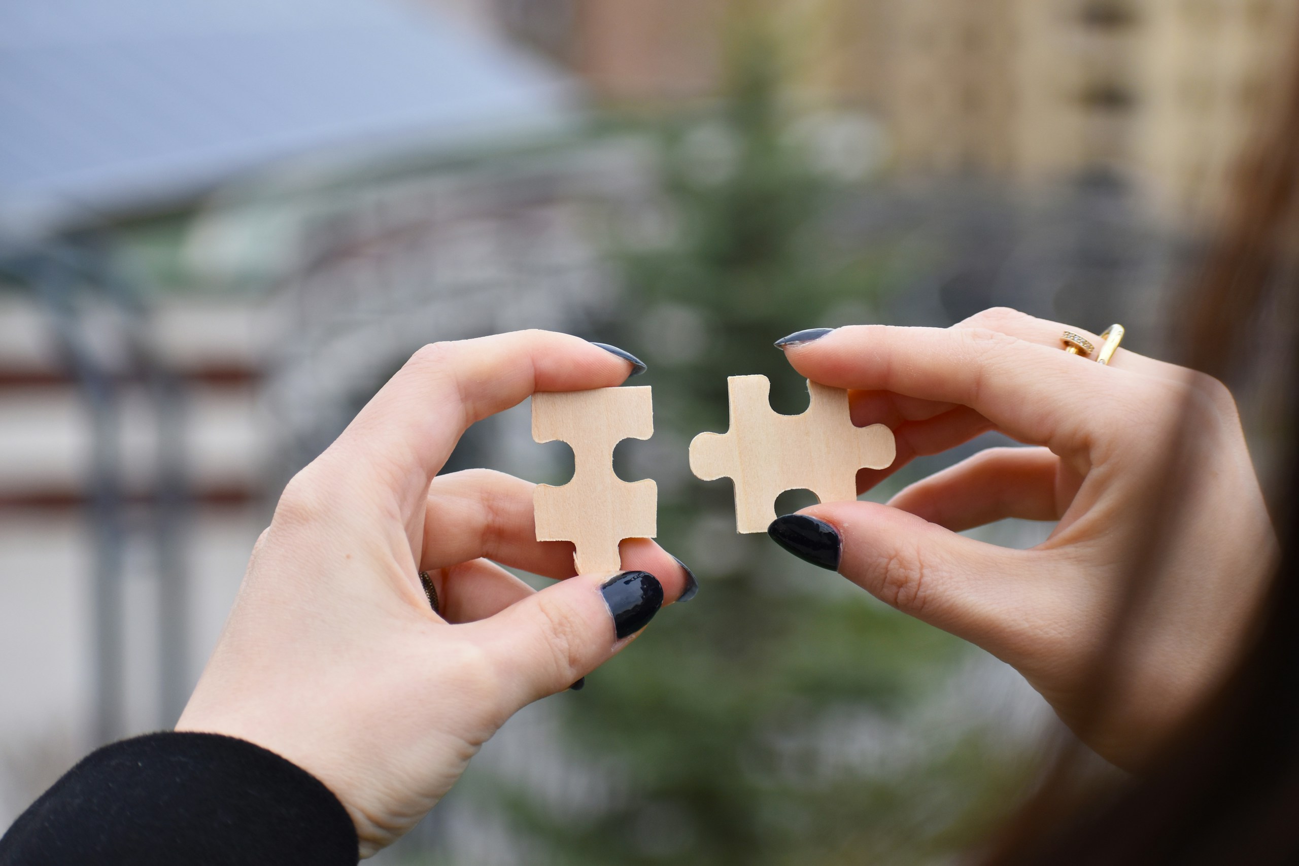 Business to business cooperation b2b concept, young woman hands showing 2 pieces of jigsaw puzzles